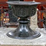 Taufbecken in schwarz auf einem Podest