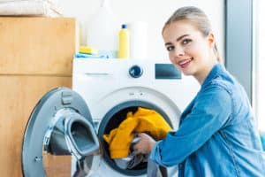 Junge Frau mit Waschmaschine