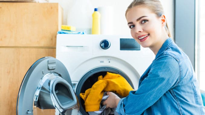 Junge Frau mit Waschmaschine