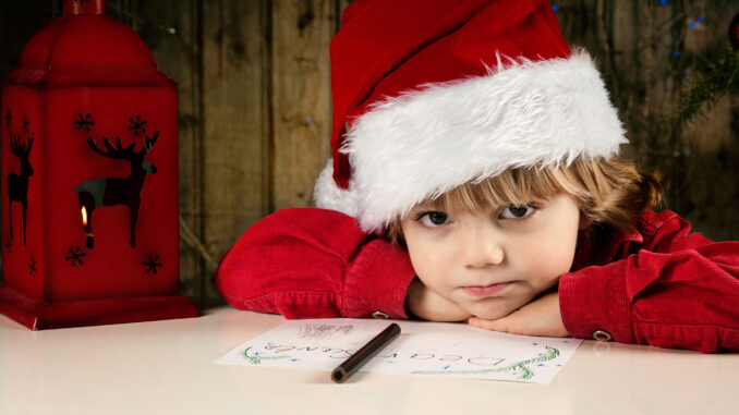 Kind mit Weihnachtsmütze als Postkarte